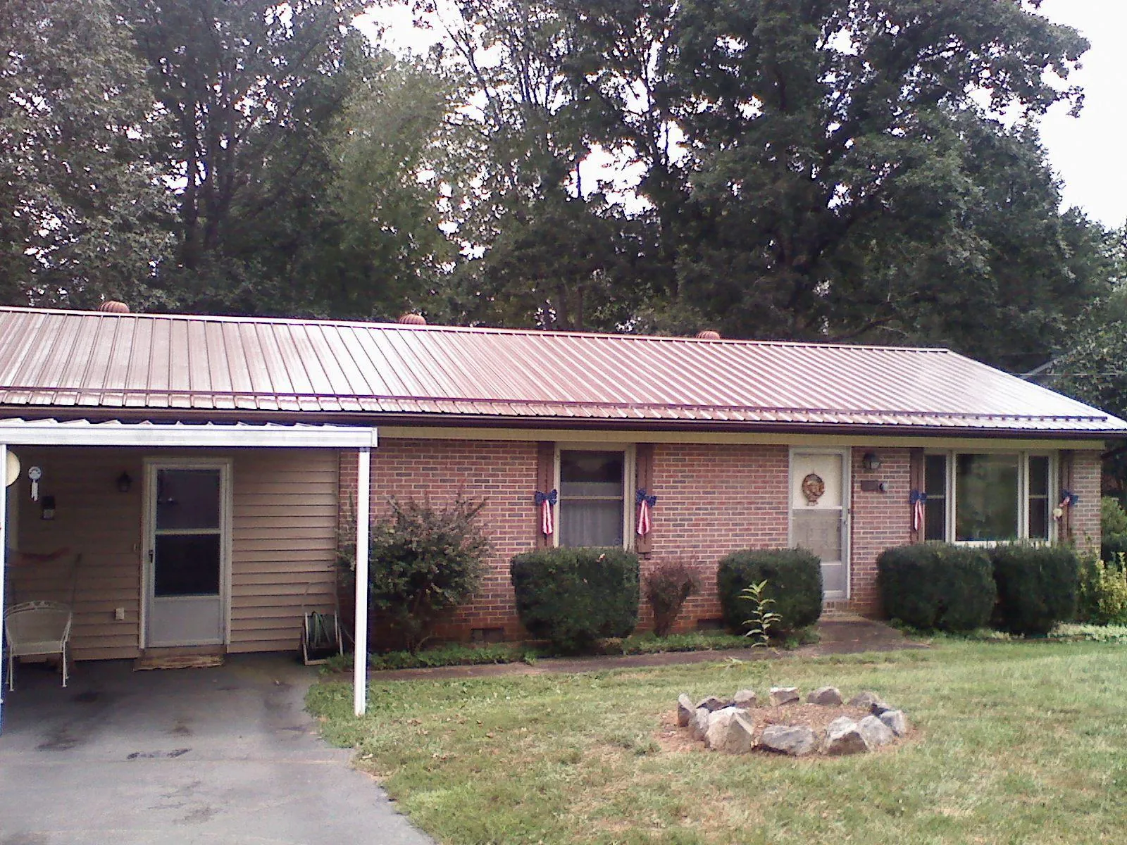 Bronze metal roof and carport on a brick ranch home — Roof Repair work by our crew in Grizzly Flats